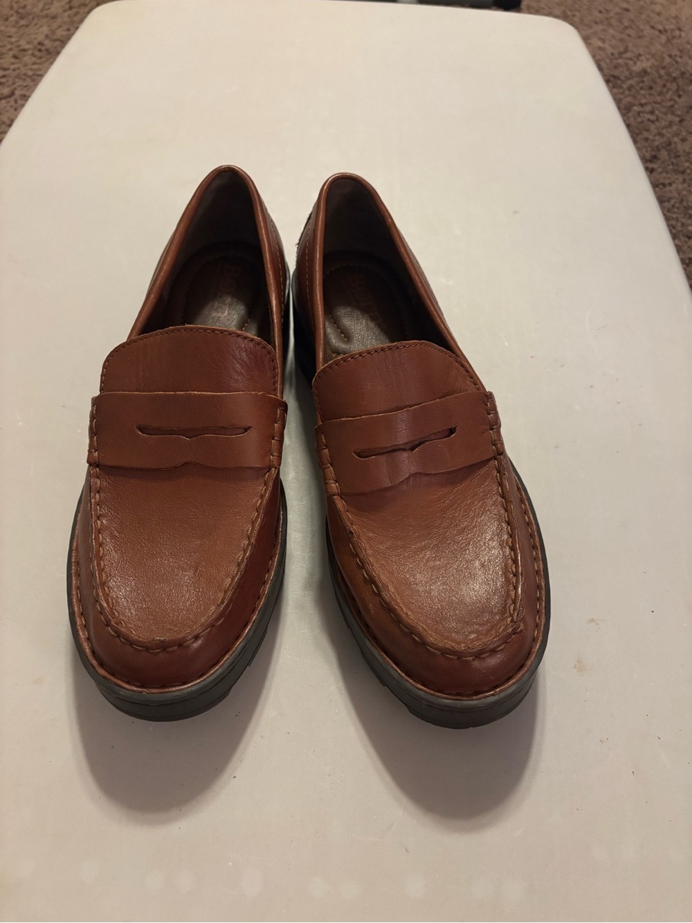 Born Carrera loafers, featuring a classic penny loafer style with a brown leathe